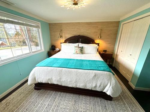 Lake CountryThe Blue House Bed and Breakfast的一间卧室设有一张大床和两个窗户。