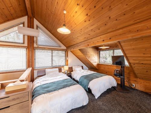 南小国町Kurokawa Mori No Kiki的配有木天花板的客房设有两张床。