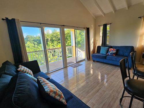 昂斯拉雷区Royal Escape - 2的客厅设有蓝色的沙发和玻璃门。