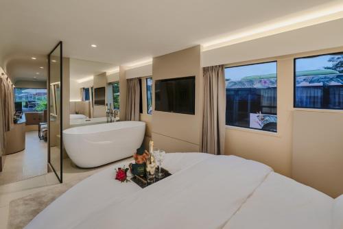 新加坡The Bus Collective的卧室配有一张白色大床和浴缸