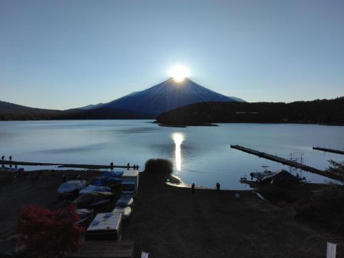 山中湖村Tabist Lakeside in Fujinami Yamanakako的享有湖泊和山脉的景色