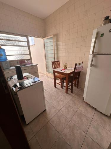 阿帕雷西达Apartamento na rua do Santuário的厨房配有桌子和白色冰箱。