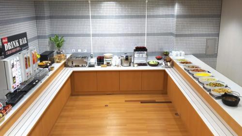 上越市Hotel Alpha-One Joetsu的厨房配有带食物盘的柜台