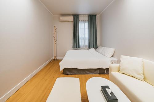 济州市Lofy house的一间带两张床和一张沙发的客厅