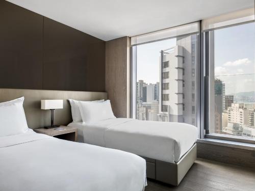 香港壹96酒店的配有大窗户的酒店客房内的两张床