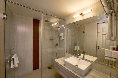 科钦Noah Sky Suites的一间带水槽和玻璃淋浴的浴室