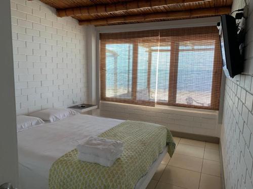 帕拉卡斯chalets cottage的一间卧室设有一张床和一个大窗户