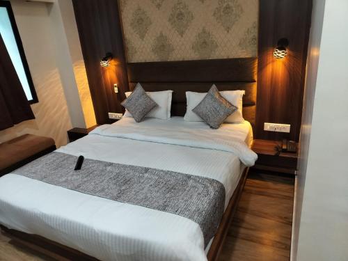 艾哈迈达巴德HOTEL RJ RESIDENCY的酒店客房,配有两张带白色床单的床