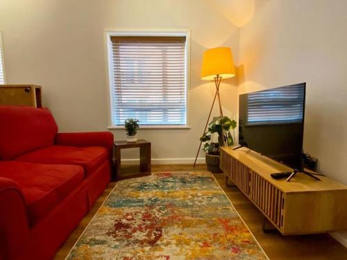 克鲁Central Crewe - Modern 1BR Haven的客厅配有红色沙发和平面电视