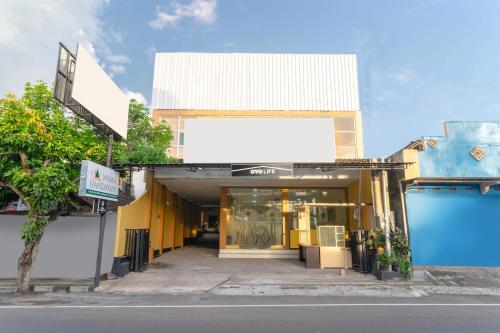 日惹OYO Life 3003 Wisma Handayani Syariah的一间商店前面有黄色和白色的建筑