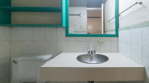马尼拉RedDoorz at Broadway Court Apartelle II Quezon City的一间带水槽、镜子和卫生间的浴室
