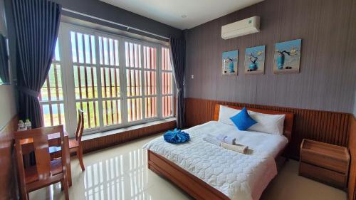 Thôn Thái AnKhu du lịch Hang Rái - Ninh Thuận的一间卧室设有一张床和一个大窗户