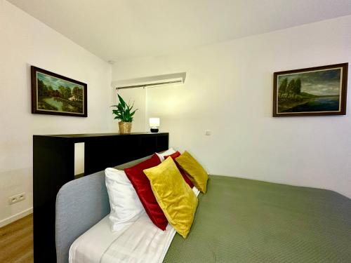 蒙斯Luxury Suites Mons的客房设有一张带色彩缤纷枕头的床。
