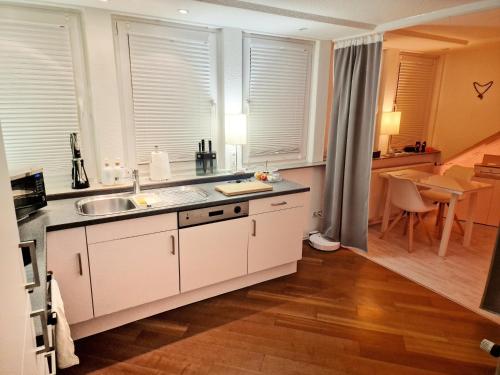 不莱梅Smartpartment Hemelingen - Shared apartment的厨房配有白色橱柜、水槽和桌子