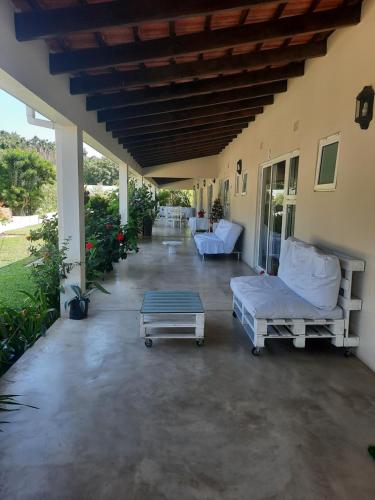 蓬塔杜欧鲁Tropicana guesthouse的一个带两张沙发和一张桌子的门廊