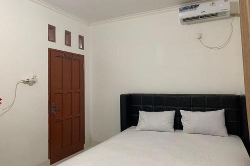 查亚普拉OYO 93485 Hotel Kenzie Sentani的卧室配有带白色床单的床和门。
