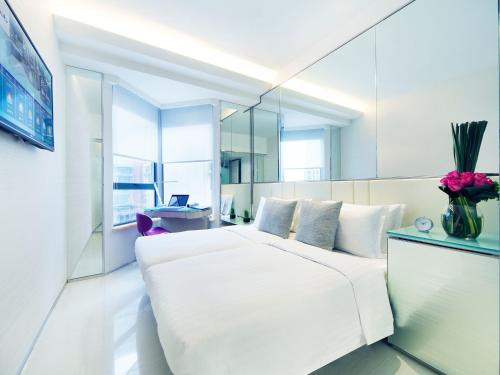 香港富荟炮台山酒店的卧室配有一张白色大床和镜子