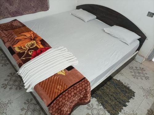 RaxaulHotel Dharam Mukti Utsav Bhawan (DMUB)的一张带毯子和枕头的未铺床