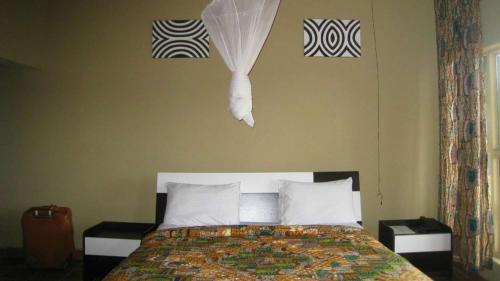 RwumbaNyungwe Hill View Hotel的一间卧室配有一张床,墙上配有一些毛巾