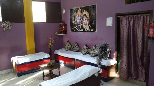 RaxaulHotel Dharam Mukti Utsav Bhawan (DMUB)的一间设有两张床的客房,墙上挂着一幅画
