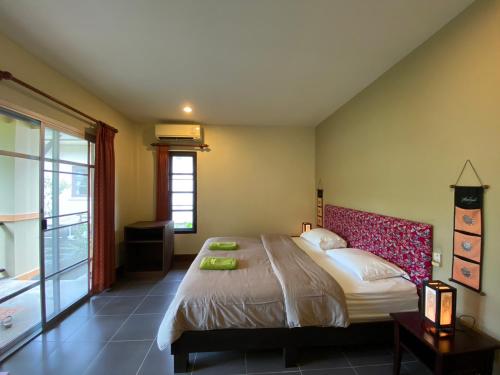蔻立Sweet Mango Khaolak的一间卧室设有一张大床和一个窗户。