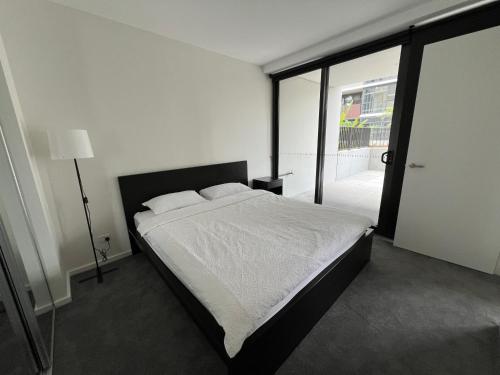 堪培拉New modern 1BR apt near Dickson的一间卧室设有一张床和一个大窗户