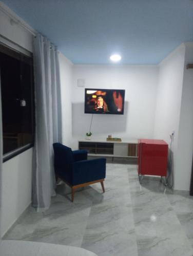 圣佩德罗-达阿尔德亚Pousada belo sol的客厅配有蓝色椅子和平面电视