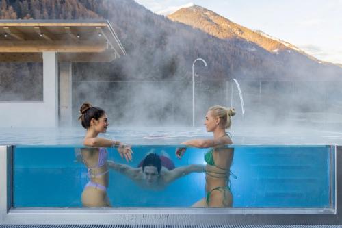 蒙克拉西科Hotel Ariston Garden & Spa的三个妇女在热水浴池里洗澡