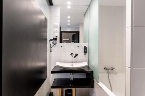南特阿斯托里亚酒店的白色的浴室设有水槽和淋浴。