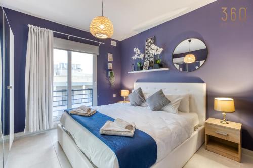 San ĠwannLUX Duplex Penthouse w/ Expansive Rooftop Terrace by 360 Estates的紫色卧室配有一张大床和镜子