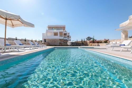 阿菲托斯Anna Mare Luxury Apartments的一个带椅子和遮阳伞的游泳池