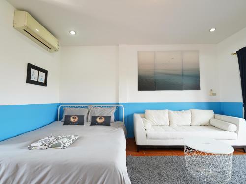 邦萨雷RoomQuest One Bangsaray的一间带两张床和一张沙发的客厅