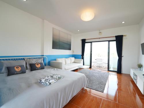 邦萨雷RoomQuest One Bangsaray的一间卧室配有一张大床和一张沙发