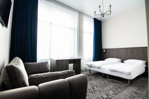希奥利艾AN Hotel的一间卧室配有一张床、一张沙发和一张床,设有窗户。