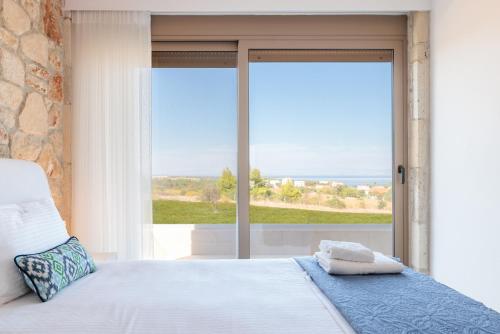 阿菲托斯Anna Mare Luxury Apartments的一间卧室设有一张床和一个大窗户