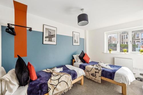 布里斯托Modern Bristol Abode - Parking and Garden的蓝色墙壁客房的两张床