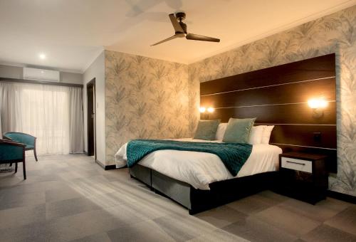 伊丽莎白港哈勃精品酒店的一间卧室配有一张大床和吊扇