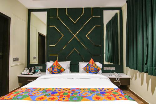 卢迪亚纳FabHotel Prime K9 Crown的一间卧室配有一张大床和色彩缤纷的毯子