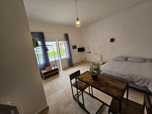 欧塞尔Gitedelatournelleauxerre的一间卧室配有一张床和一张木桌及桌子