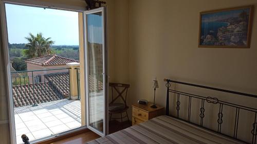 贝济耶Villa Pays d'Oc的卧室设有1张床铺和1扇滑动玻璃门的阳台