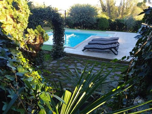 多尔梅莱托Margot Ca Bianca Dormelletto Lago Maggiore的花园内带2个长椅的游泳池