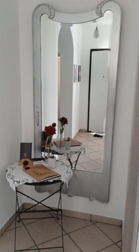 多尔梅莱托Margot Ca Bianca Dormelletto Lago Maggiore的白色房间的大镜子,配有桌子和桌子