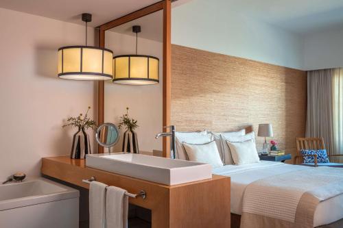 维拉摩拉Anantara Vilamoura Algarve Resort的一间卧室配有一张带水槽和镜子的床