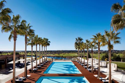 维拉摩拉Anantara Vilamoura Algarve Resort的棕榈树和游泳池度假村