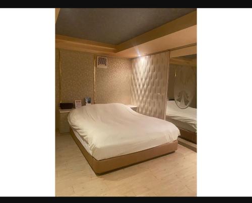 Ichiharaラフォーレ的卧室配有白色的床和镜子