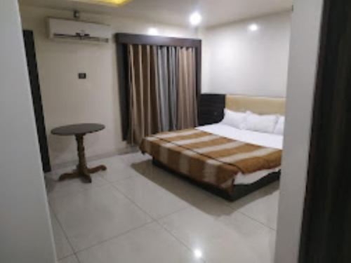 SāgarHotel 100 Blu Madhya Pradesh的一间卧室配有一张床和一张桌子