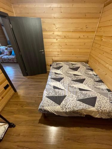 普里什蒂纳Shpija e Liqenit的卧室,卧室配有一张床,卧室位于带门的房间