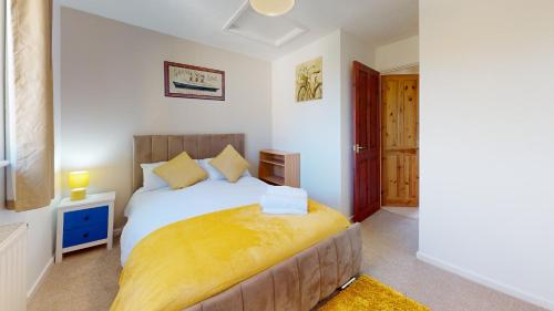 MiltonCosy 2 double bed property in Milton的卧室配有一张白色大床和黄色床单