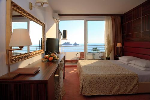佩特罗瓦纳莫鲁帕拉斯酒店的酒店客房,配有床和镜子