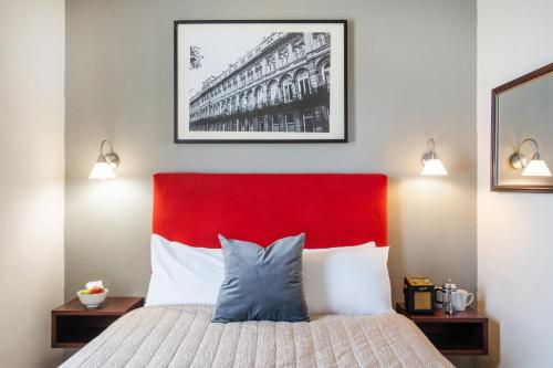 布里斯托布里斯托尔克利夫顿酒店的一间卧室配有红色床头板和一张带枕头的床